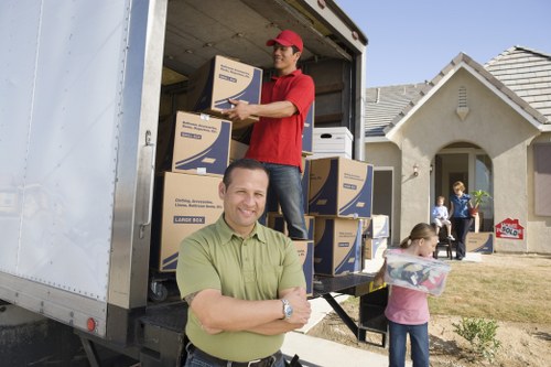 Professional movers handling boxes and furniture in a Hollandpark property