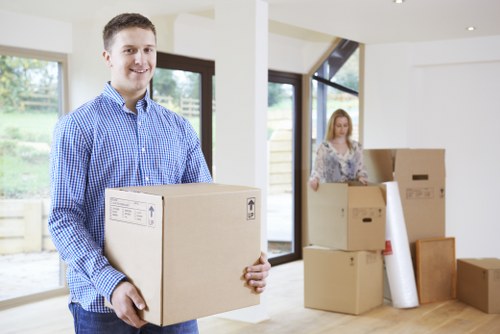 Staff using safe lifting techniques while moving furniture through a property